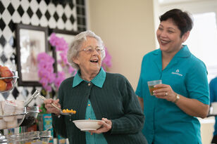 smiling resident of aged care home being embraced outside of the nursing home
