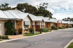 elderly aged care resident sitting down outside the nursing home with two baptistcare aged care workers